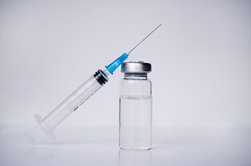 Ampoules and syringe with Covid-19 vaccine on a laboratory table.For the prevention, immunization and treatment of coronavirus infection.Infectious medicine concept. With copy space
