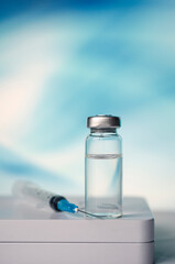 Ampoules and syringe with Covid-19 vaccine on a laboratory table.For the prevention, immunization and treatment of coronavirus infection.Infectious medicine concept. With copy space