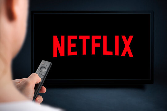 USA, NEW YORK February 2, 2021: Close up of Nvidia Sheild TV Remote in Hand and TV Screen with Netflix Logo, Netflix is a well known global provider of streaming movies