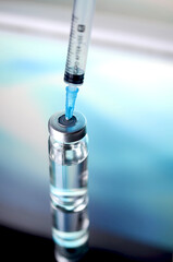 Ampoules and syringe with Covid-19 vaccine on a laboratory table.For the prevention, immunization...