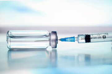 Ampoules and syringe with Covid-19 vaccine on a laboratory table.For the prevention, immunization...