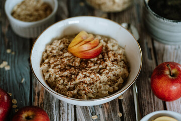 A porridge bowl with apples and cinnamon, food still life, healthy breakfast