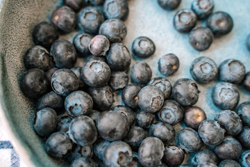 Blueberries are scattered on a white towel