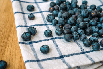 Blueberries are scattered on a white towel