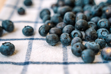 Blueberries are scattered on a white towel