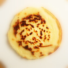 Single pancake made of flour with a sharp center in a frame and blurred cuts made from fresh flour prepared for Shrovetide.