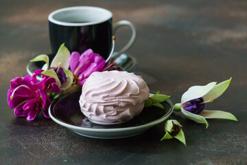 Delicious pink marshmallows on the table with a cup of coffee.