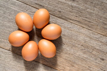 Chicken eggs on the wooden board background with a copy space. Flat lay.