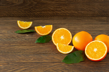Fresh oranges with green eaves on rustic wooden background with copy cpace