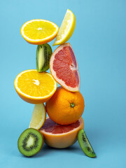 Balancing fruits on a blue background.