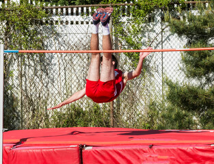 Athlete falling over the high jump bar with a successful jump