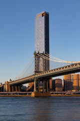 Obraz premium The Manhattan Bridge over the East River and the Lower East Side Skyline in New York City with a Clear Blue Sky
