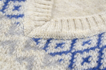 Detail of wool beige blue diamond pattern  sweater