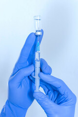 Doctor hands holding a vaccine bottle and syringe,beginning of worldwide mass vaccination for coronavirus COVID-19,influenza or flu,world immunization concept. Selective focus