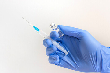 Doctor hands holding a vaccine bottle and syringe,beginning of worldwide mass vaccination for coronavirus COVID-19,influenza or flu,world immunization concept. Selective focus