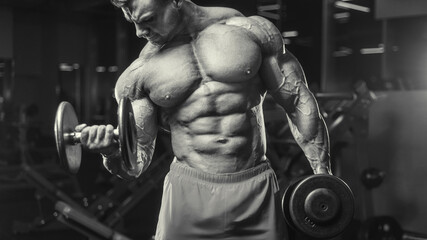 Fototapeta na wymiar Bodybuilder strong man pumping up biceps muscles