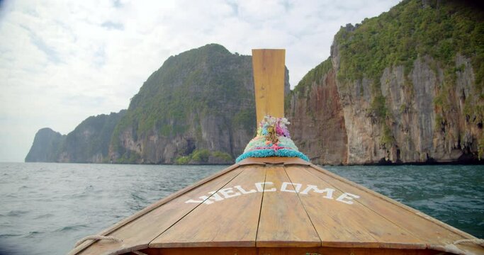 The boat sales through the waves to the mountain lagoon of Phi Phi island