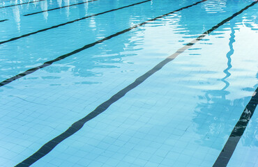 Closeup to calm pool water, swimming lanes visible at tiled bottom