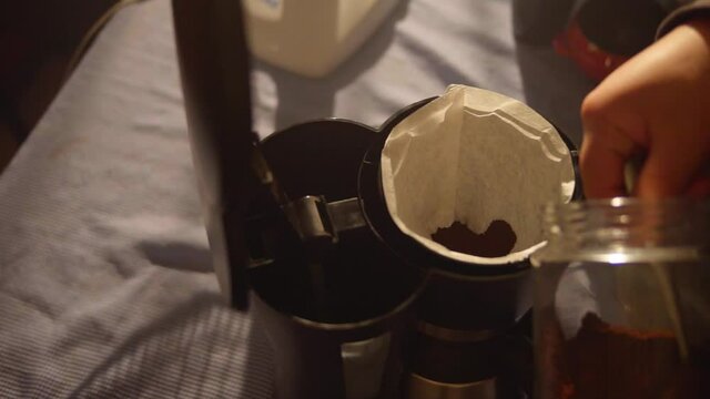 Putting coffee in the coffee maker