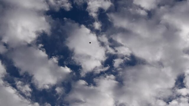kite flying free high in the sky among the clouds. isolated kite flying high in sky, concept of freedom