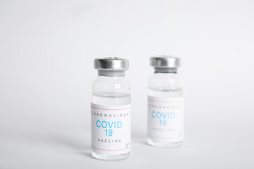 Vials with coronavirus vaccine on white background