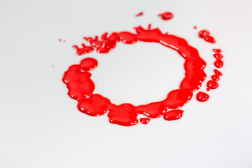 .Red ink dripping circles on the ground of a rotating white object.