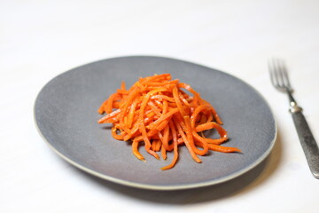 Korean spicy cappot with garlic and sauce salad on gray plate with fork on white wooden background