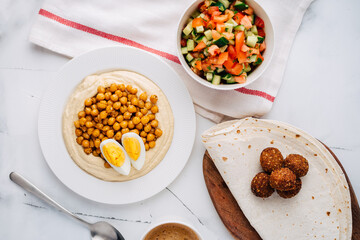Hummus with boiled chickpeas, egg, falafel, lavash and salad. Flat Lay. Top view