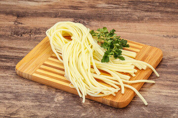 Chechil spaghetti cheese over board