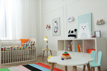 Cute baby room interior with stylish furniture and toys