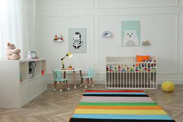 Cute baby room interior with stylish furniture and toys