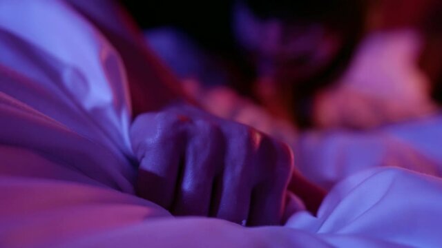 voluptuous woman is grabbing blanket on bed, posing sexually at night, sex and passion in bedroom