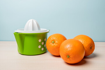 Closeup of the fresh oranges and a juicer on a table