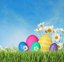Bright Easter eggs and spring flowers on green grass outdoors