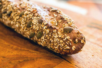 Homemade sourdough bread with fenugreek, sesame seeds, pumpkin seeds and flax seeds on a wooden board close up