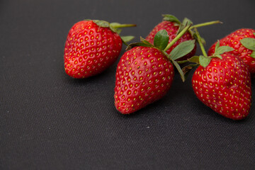 fresh large berries of garden strawberries lie on a dark background