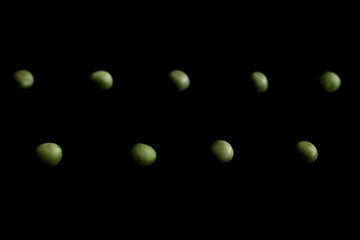 Green peas on the black background