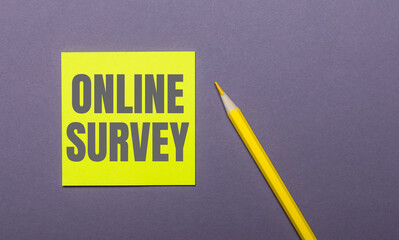 On a gray background, a bright yellow pencil and a yellow sticker with the words ONLINE SUVEY