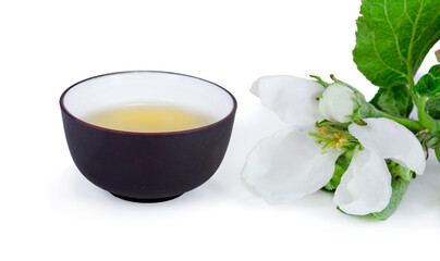 Green tea in a ceramic cup with branches of blossoming apple tree isolated on a white background. 