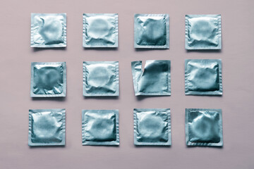 pattern of many blue condoms and empty package on pink background