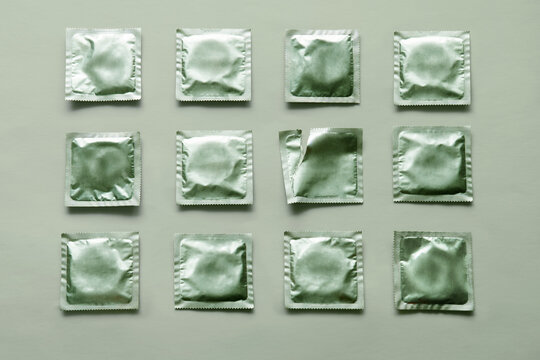 pattern of many green condoms and empty package on green background
