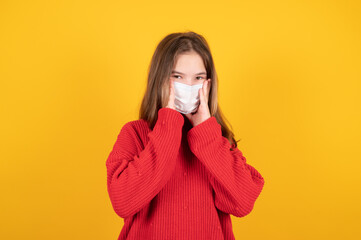 Portrait of young teen girl putting on a protective mask.