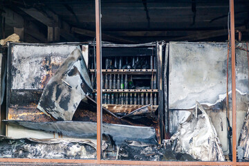 An ambulance with fire trucks at the site of a fire, a shopping center in the city center,