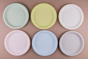 set of plastic reusable colorful plates on the kitchen table