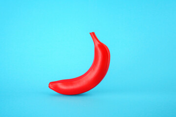 Red banana on a blue background. Fake GMO product concept