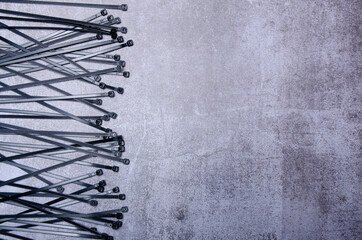 Plastic cable ties on gray concrete background, top view space for text