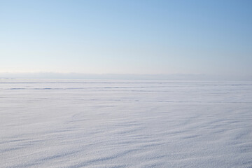 Winter landscape with snow-covered sea and blue sky with clear air.