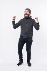 Full length photo of bearded hipster man celebrating over white background.