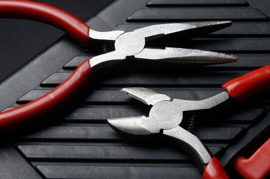 The flat nose pliers and pasatige are on the tool box. close-up.