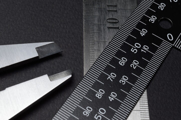 measuring tool, ruler square and caliper. lie on a dark background. close-up.